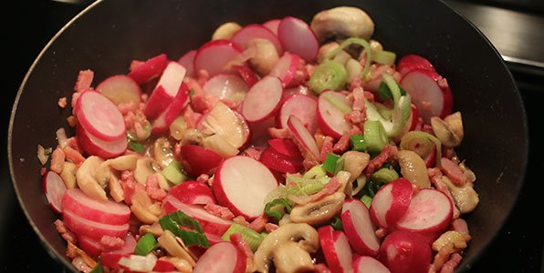Radijs, spekjes en champignons samen in een hapjespan