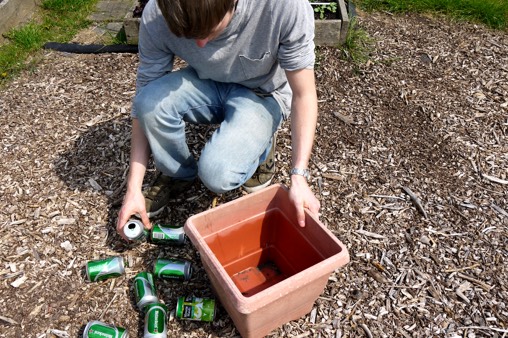 Vul de bodem van te diepe potten op met blikjes