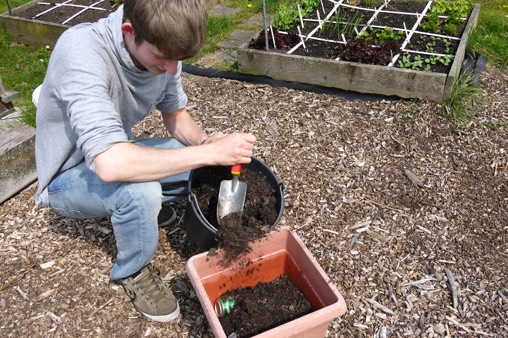 Vul de onderste helft van een diepe pot met compost