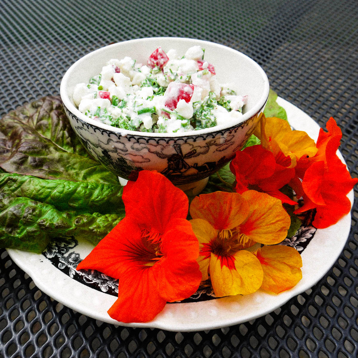 Salade opkleuren met bloemen van de Oost-Indische kers
